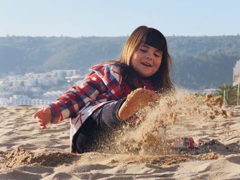 Cute girl playing on sandy beach