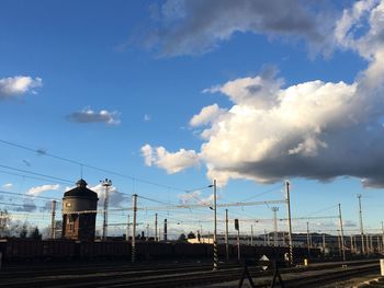 Train at railroad station in city against sky