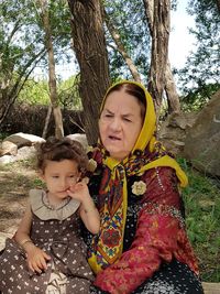 Grandmother sitting granddaughter at park