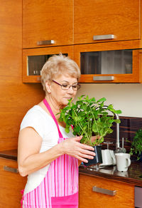 Woman with arms raised standing at home