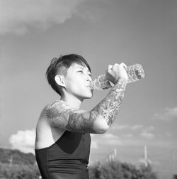 Side view of young man standing against wall