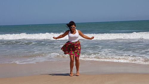 Full length of young woman standing on beach