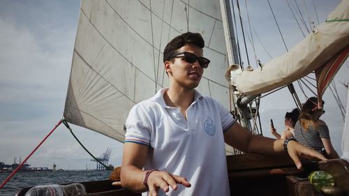 Man standing in boat against sky