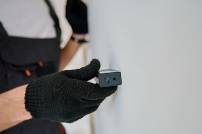 Midsection of man holding equipment against white background