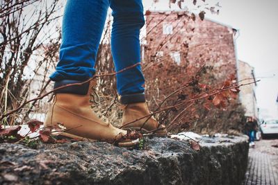 Low section of woman standing on retaining wall