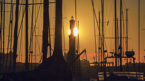 Silhouette of sailboats at harbor during sunset