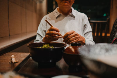 Midsection of man having food in restaurant