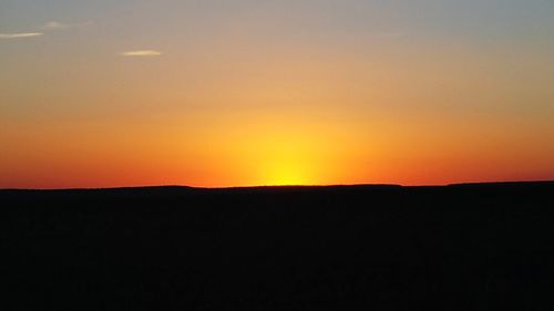 Silhouette landscape against clear sky during sunset