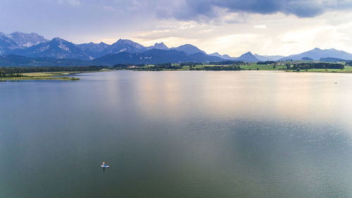 Scenic view of lake by mountains against sky