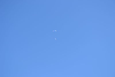 Low angle view of moon against clear blue sky