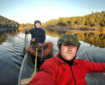 Portrait of young man in lake against sky
