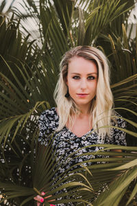 Portrait of young woman with palm leaves