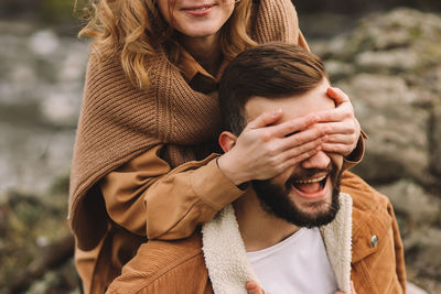 A romantic couple in love in warm sweaters is walking traveling by car in the autumn forest in fall