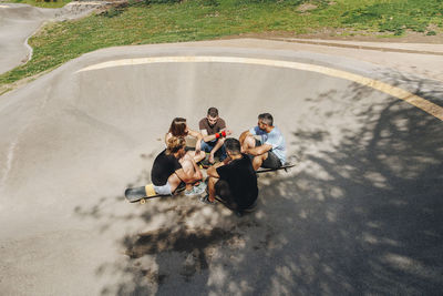 Friends sitting on ramp talking at skateboard park