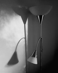 Close-up of electric lamp on table against wall