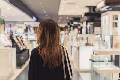 Rear view of woman standing at store