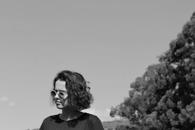 Close-up of woman wearing sunglasses against clear sky