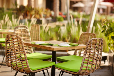 Terrace of a cozy cafe in green tones with wicker furniture under the open sky. street cafe