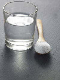 Close-up of powdered sugar with water in drinking glass on table