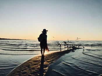 Full length of silhouette woman on beach against sky during sunset