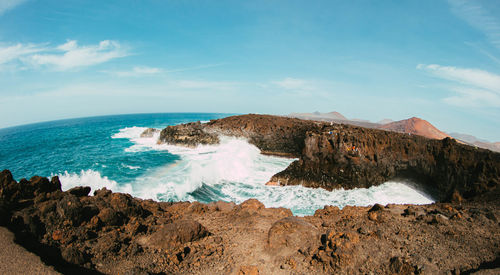 Panoramic view of rocks on beach against sky