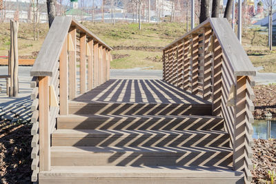 Wooden bridge in the park and railing hard shadows