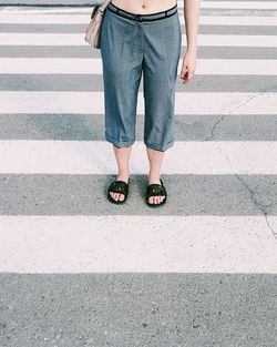 Low section of man standing on road