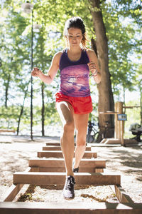 Full length of woman exercising at outdoor gym