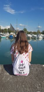 Rear view of girl on shore against sky