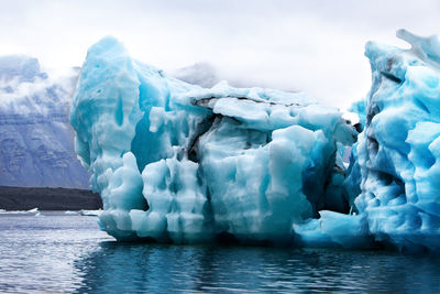 Glaciers on lake against sky