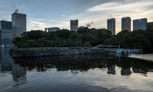 Lake and buildings against sky in city