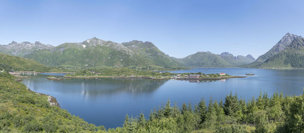 Scenic view of lake and mountains against blue sky