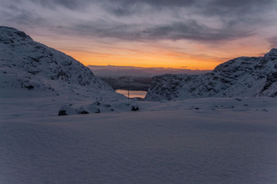 Scenic view of snow covered mountains against sky during sunset