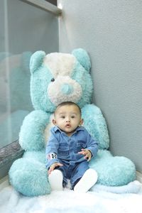 Cute baby girl sitting on toy at home