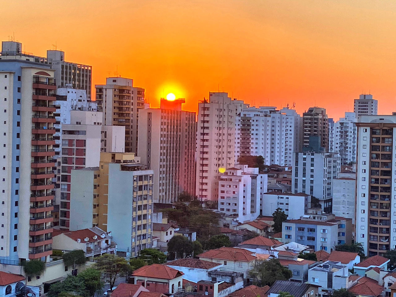 HIGH ANGLE VIEW OF BUILDINGS AGAINST SKY AT SUNSET