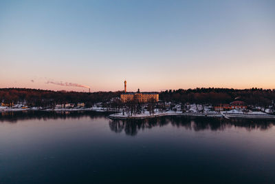 Scenic view of lake against clear sky at sunset