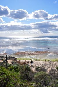 People on sea shore against sky