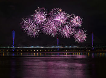 Firework display over river at night