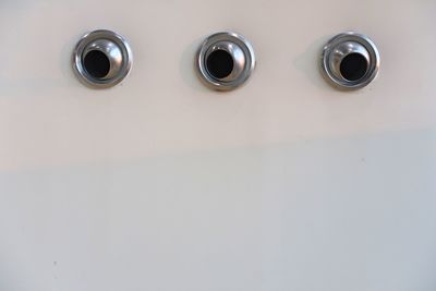 Close-up of metal air conditioning holes on white wall