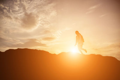 Silhouette man against sky during sunset