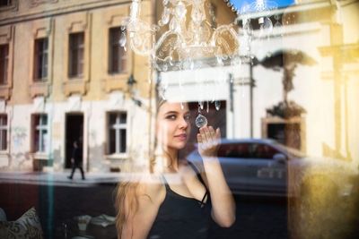 Portrait of young woman with reflection on window