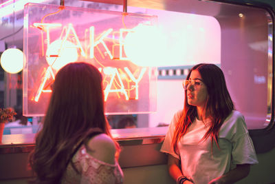 Young woman standing in illuminated room