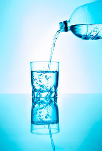 Close-up of drink glass against blue background