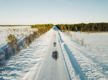 Road amidst snow covered land against sky