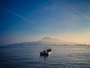 People on boat in sea against sky