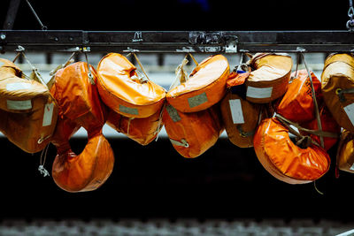 Close-up of life jackets hanging on metal