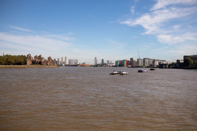 Sea by buildings against sky in city