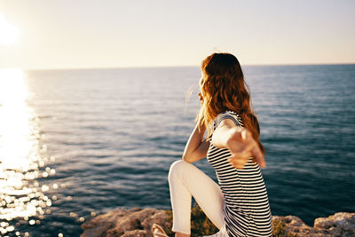 Rear view of woman looking at sea against sky