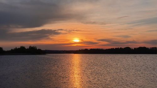 Scenic view of lake against orange sky