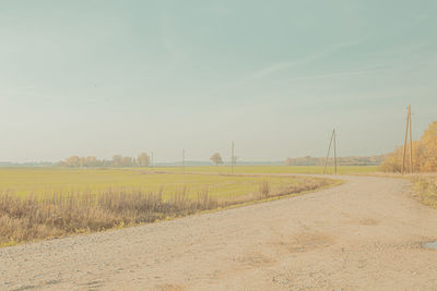 Road amidst field against sky